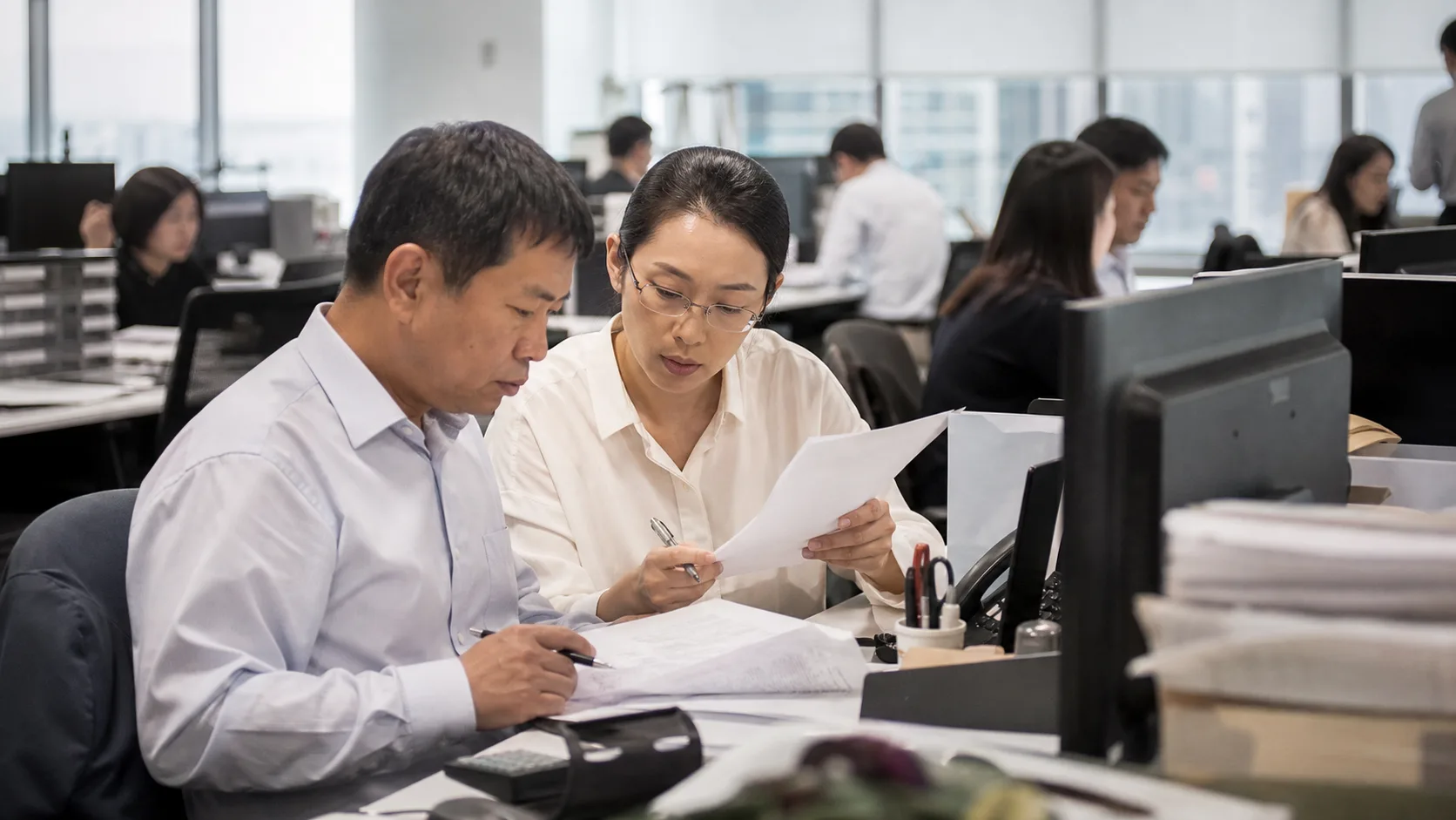 銀行の事務室で国際商取引の決済書類を確認する担当者